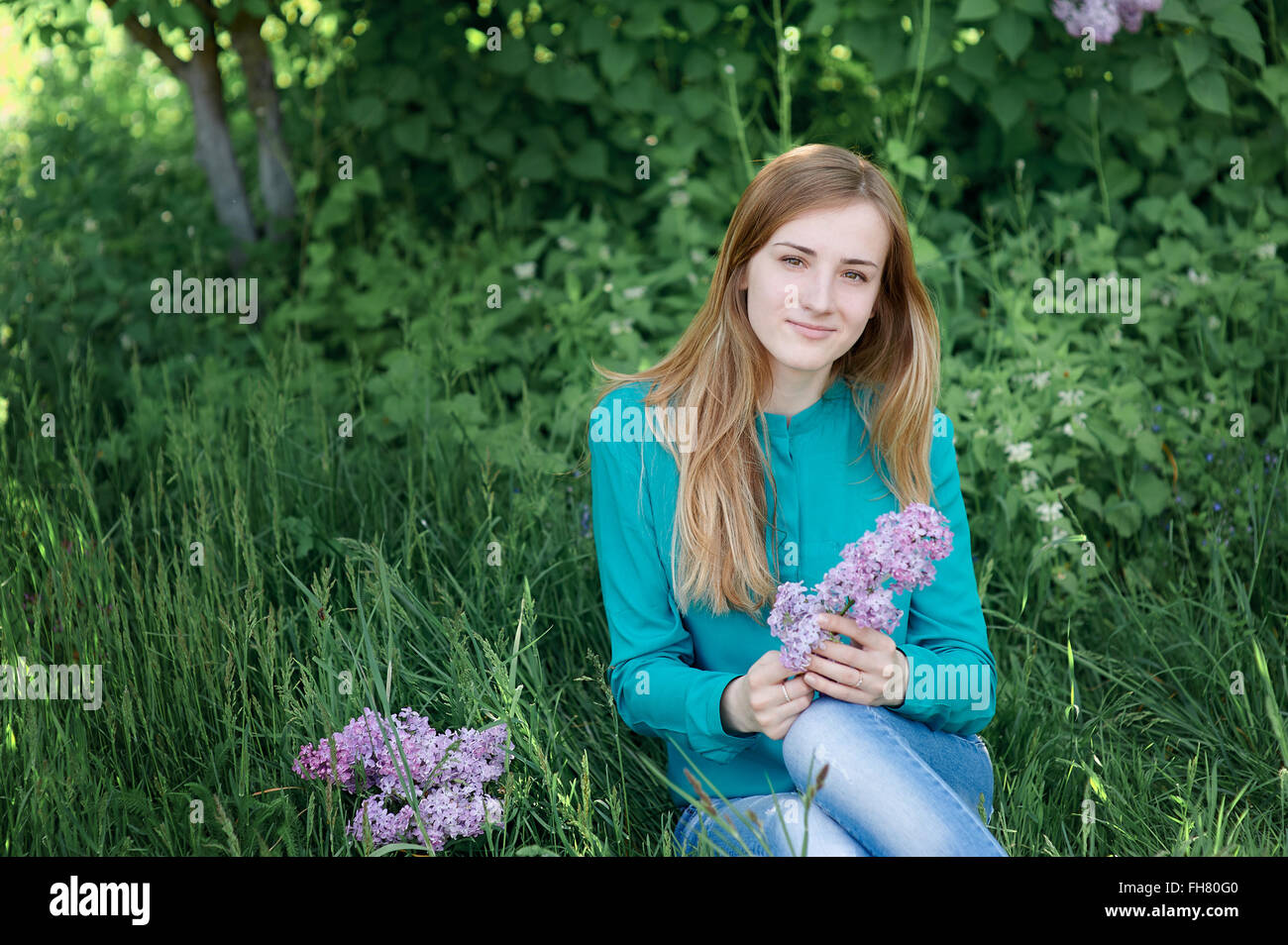 beautiful woman with a branch of lilac in the spring garden Stock Photo ...