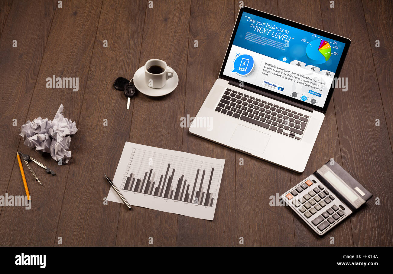 Laptop on office desk with business website on screen Stock Photo