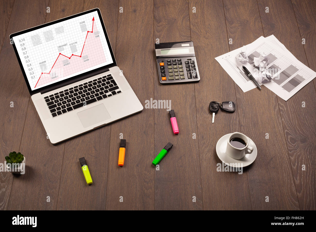 Computer desk with laptop and red arrow chart in screen Stock Photo - Alamy