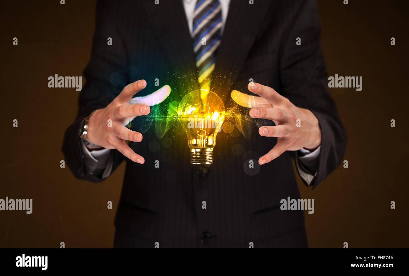Businessman holding light bulb Stock Photo - Alamy