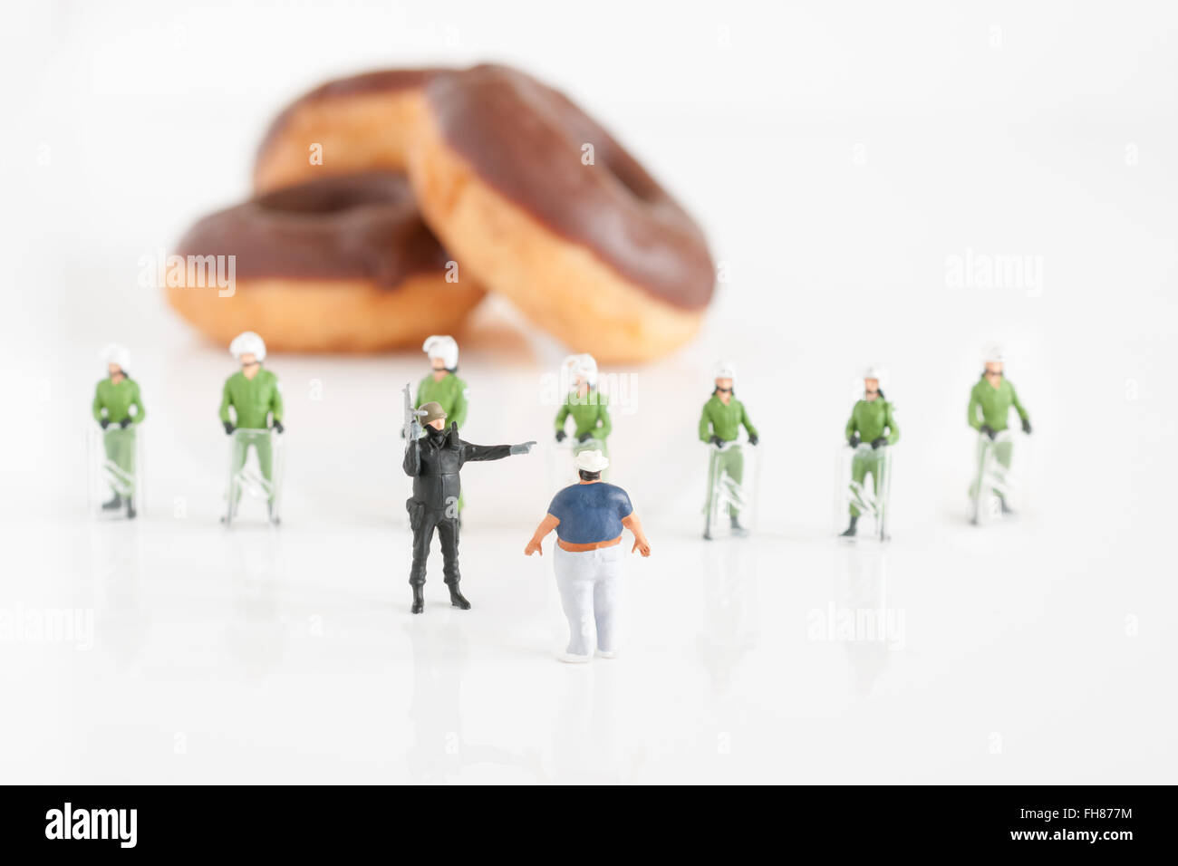 Police in riot gear preventing an overweight man from reaching donuts a ...