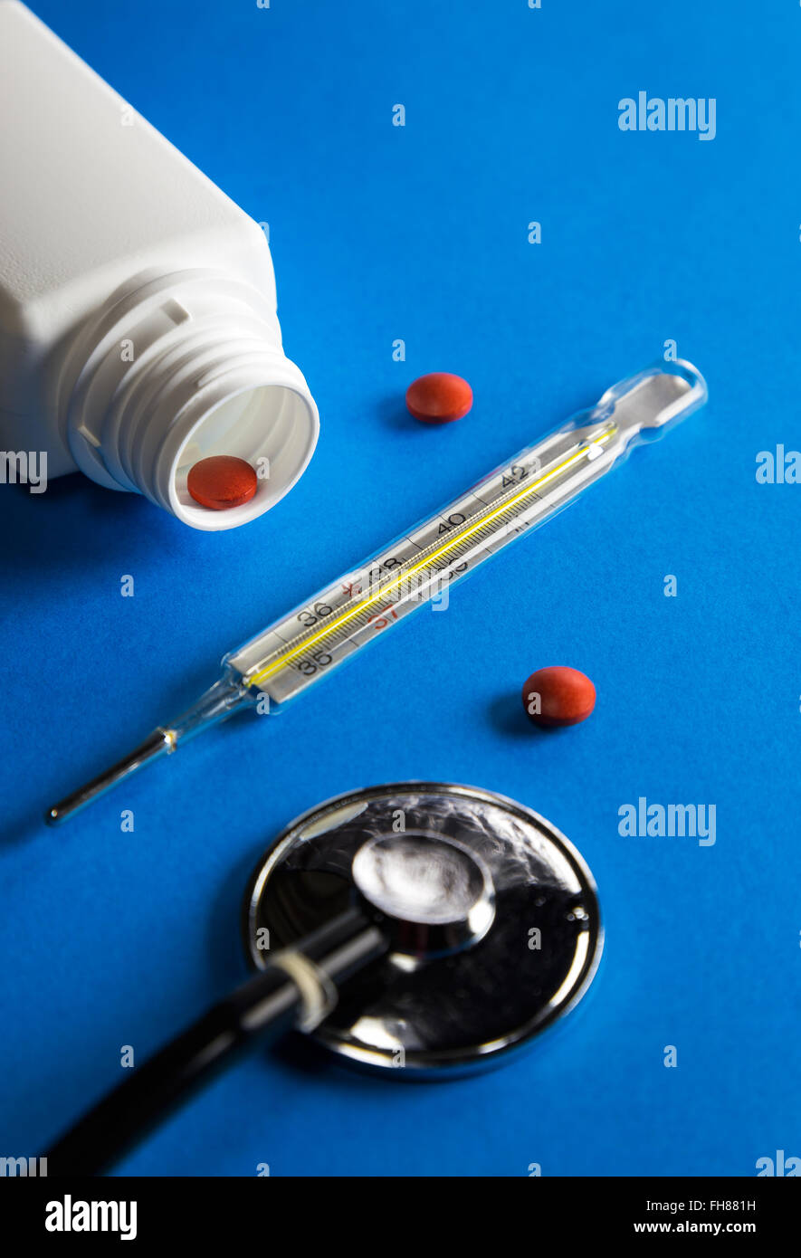 Mercury thermometer drugs and stethoscope on blue background Stock