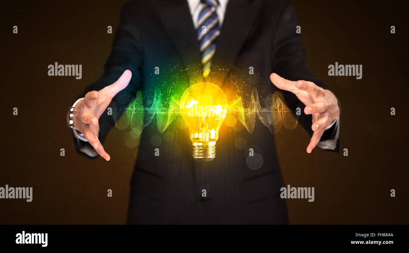 Businessman holding light bulb Stock Photo - Alamy