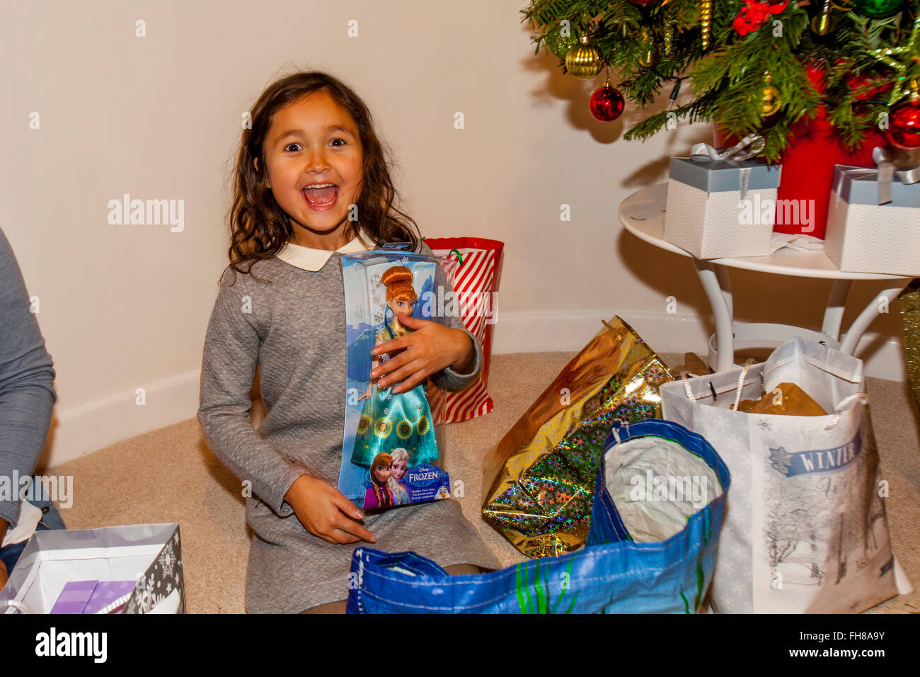 A Mixed Race Child Opening Her Christmas Presents On Christmas Day, Brighton, Sussex, UK Stock Photo