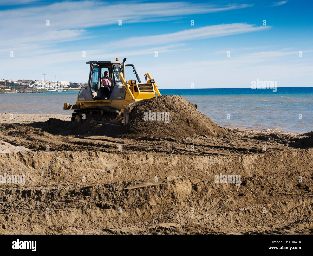 Bulldozer, Beach sand regeneration eroded by waves, Mijas Malaga province Costa del Sol. Andalusia southern Spain Stock Photo