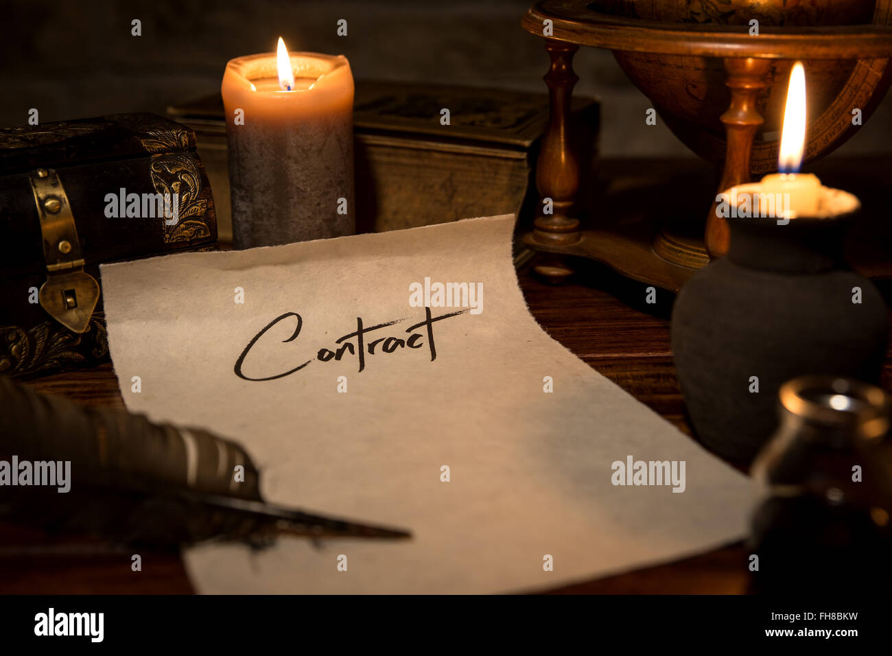 a parchment paper with a quill and ink, candles and medieval decoration, concept contract Stock Photo
