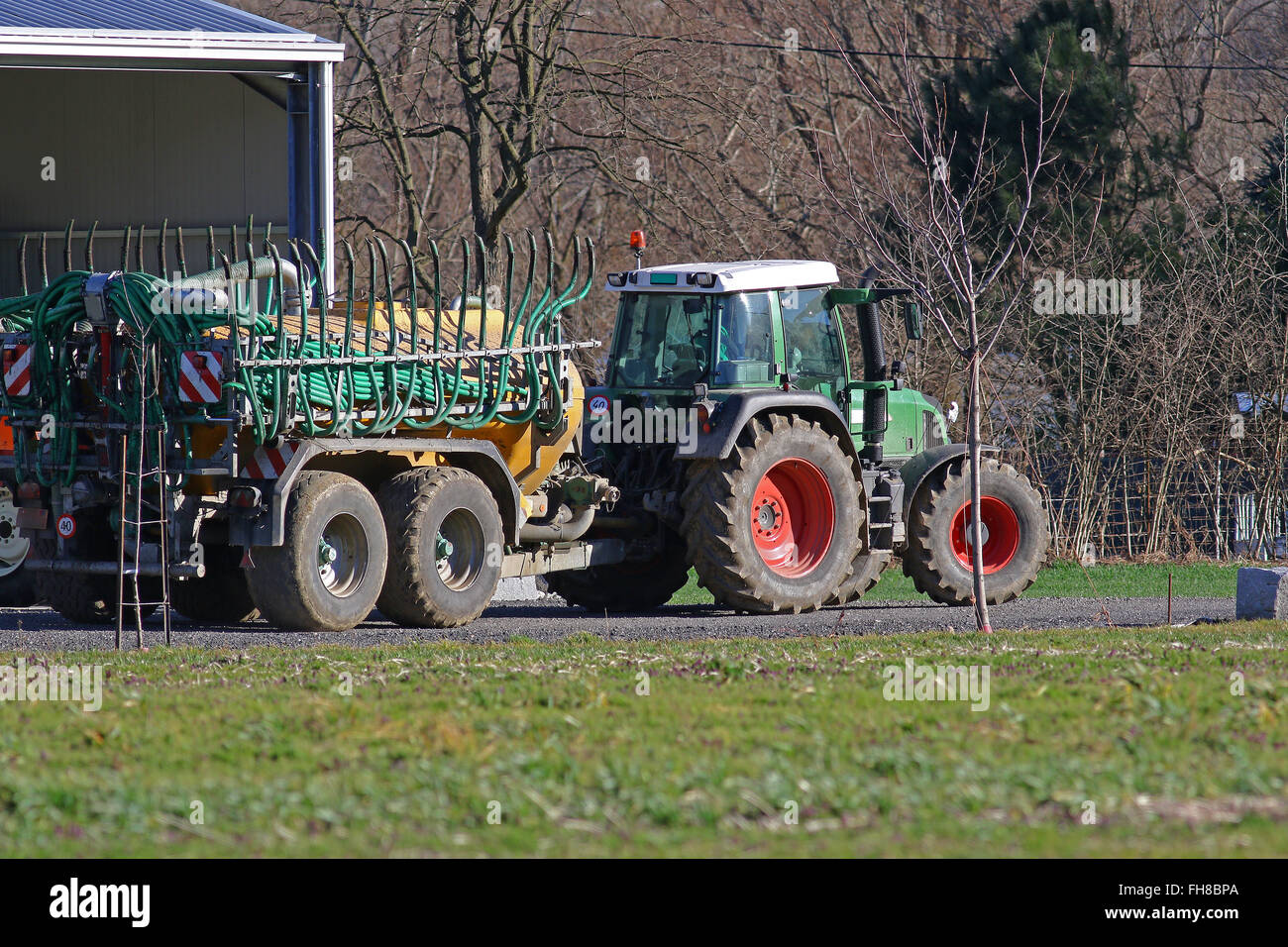 Agricultural tractor pulling a trailer on a farm road Stock Photo Alamy