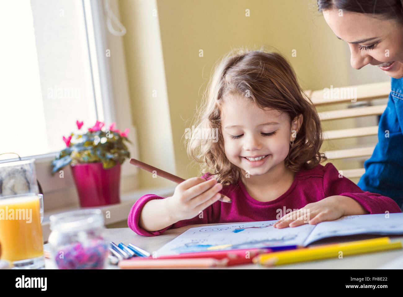 Portrait of smiling little girl painting with coloured pencils Stock ...