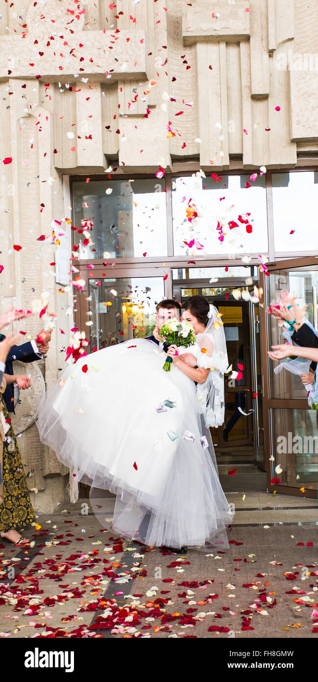 Guests Throwing Confetti Over Bride And Groom At Wedding Stock Photo