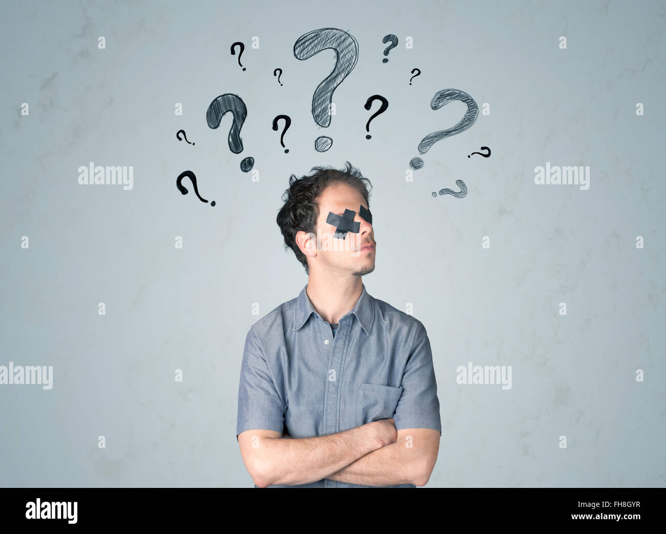 Young man with glued eye and question mark symbols Stock Photo Alamy