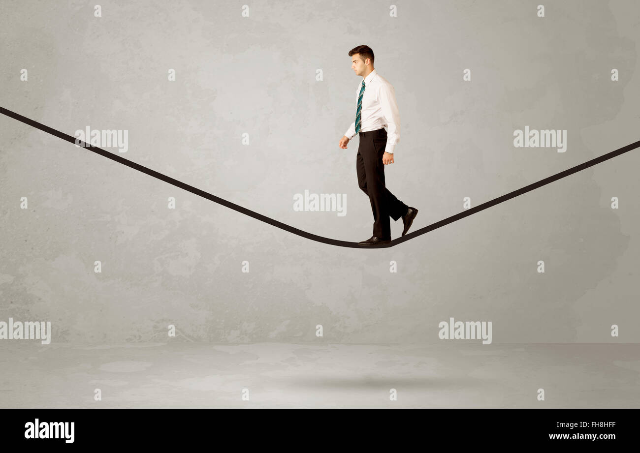 Salesman walking on rope in grey space Stock Photo - Alamy