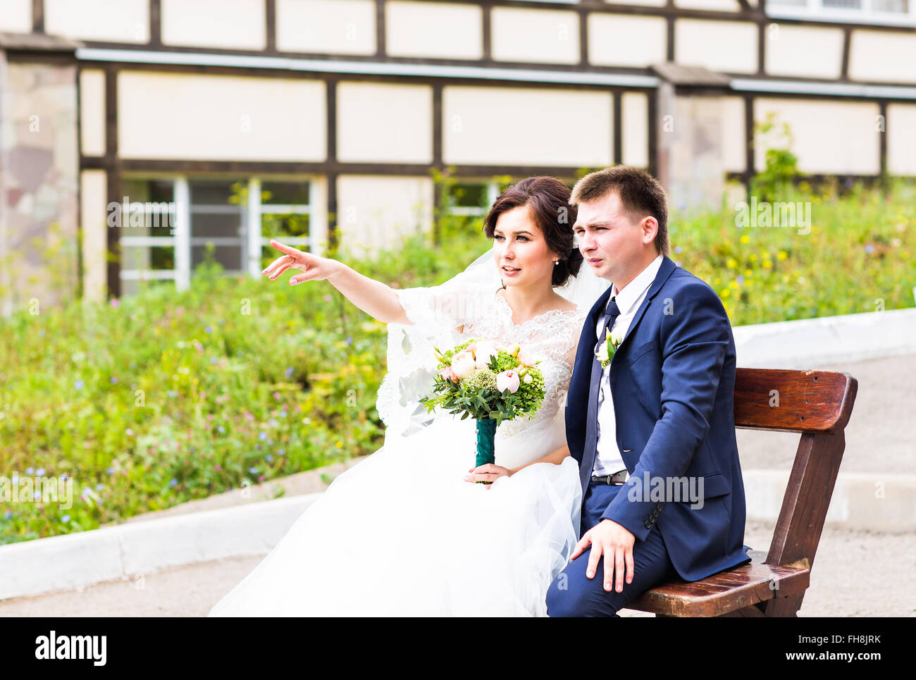 Romantic wedding couple sitting on a bench in the park Stock Photo - Alamy