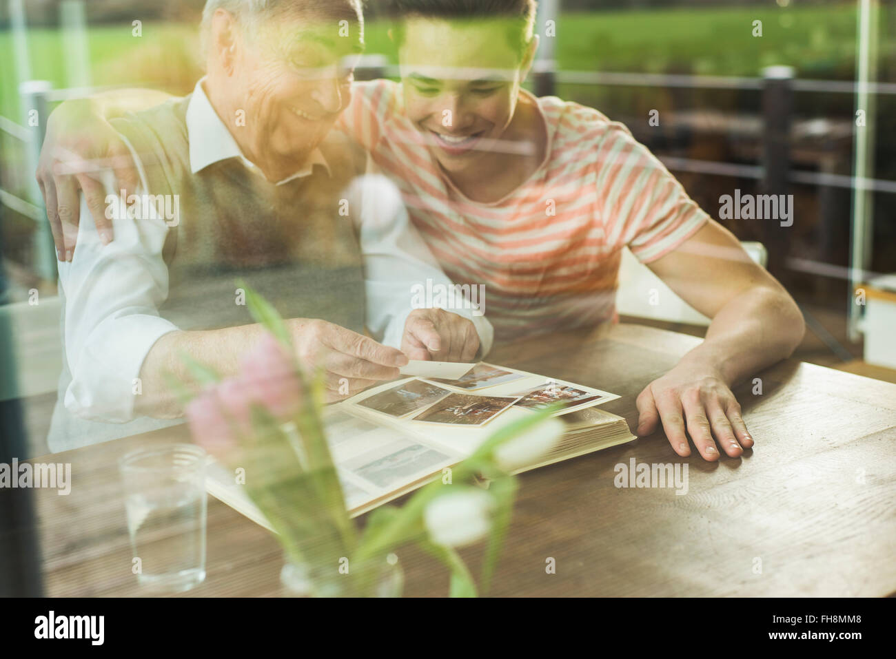 Grandfather and grandson watching old photographies together Stock Photo