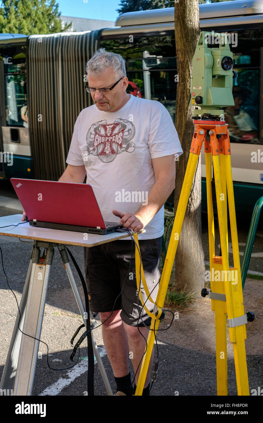 Land surveyor taking measures with Leica TCR 307 theodolite and laptop  computer - Stock Image