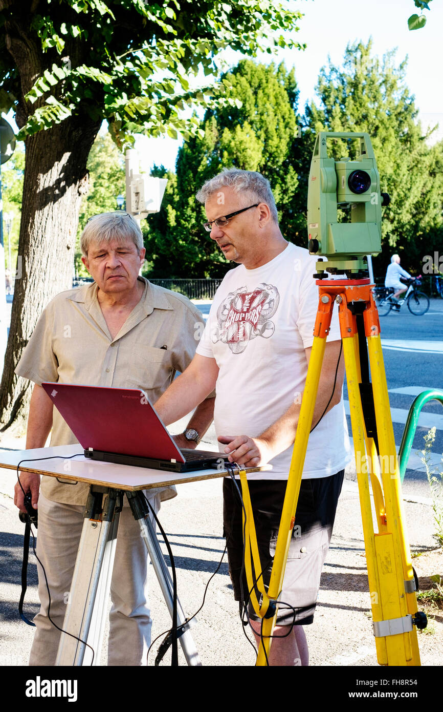 Land surveyors taking measures with Leica TCR 307 theodolite and laptop computer Stock Photo