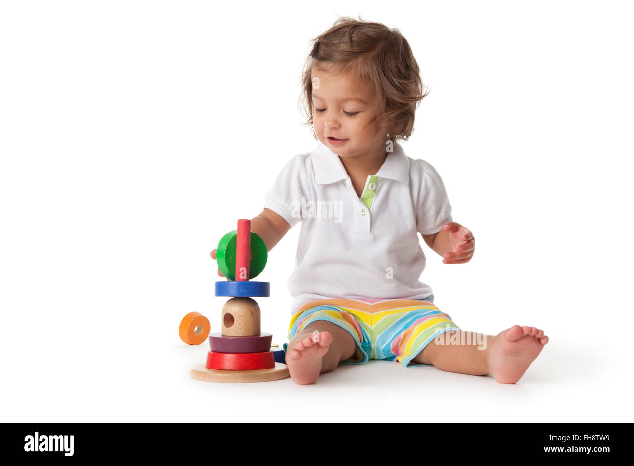 Toddler girl playing with colored bricks on white background Stock Photo