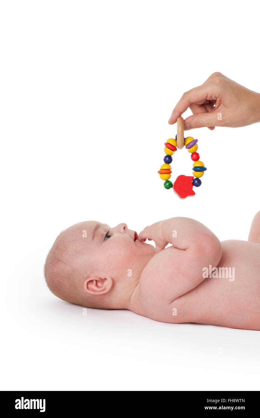 Baby boy looking at a colored toy on white background Stock Photo