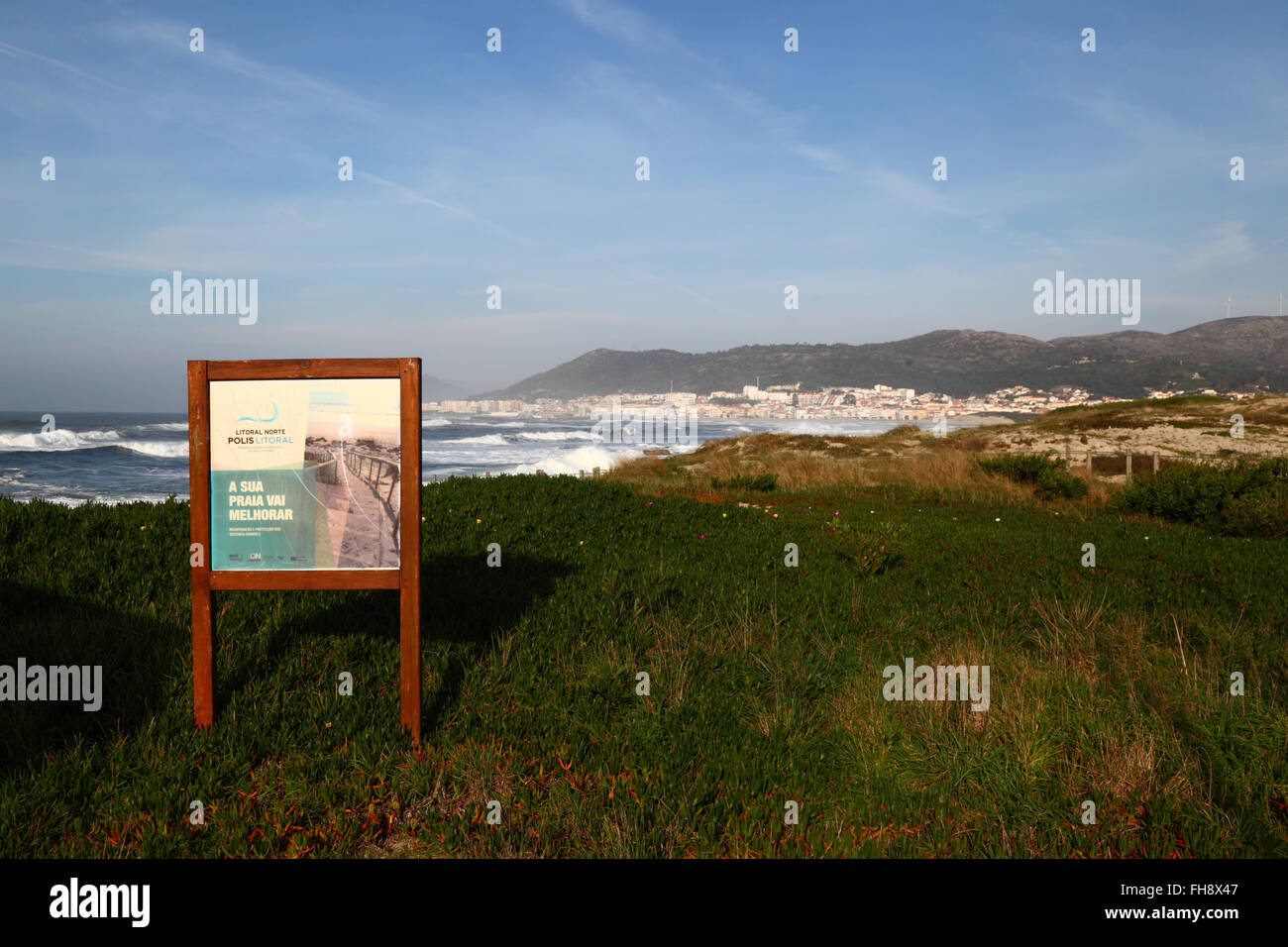 Sign for project to restore vegetation on sand dunes, Vila Praia de Ancora in background, Minho Province, northern Portugal Stock Photo