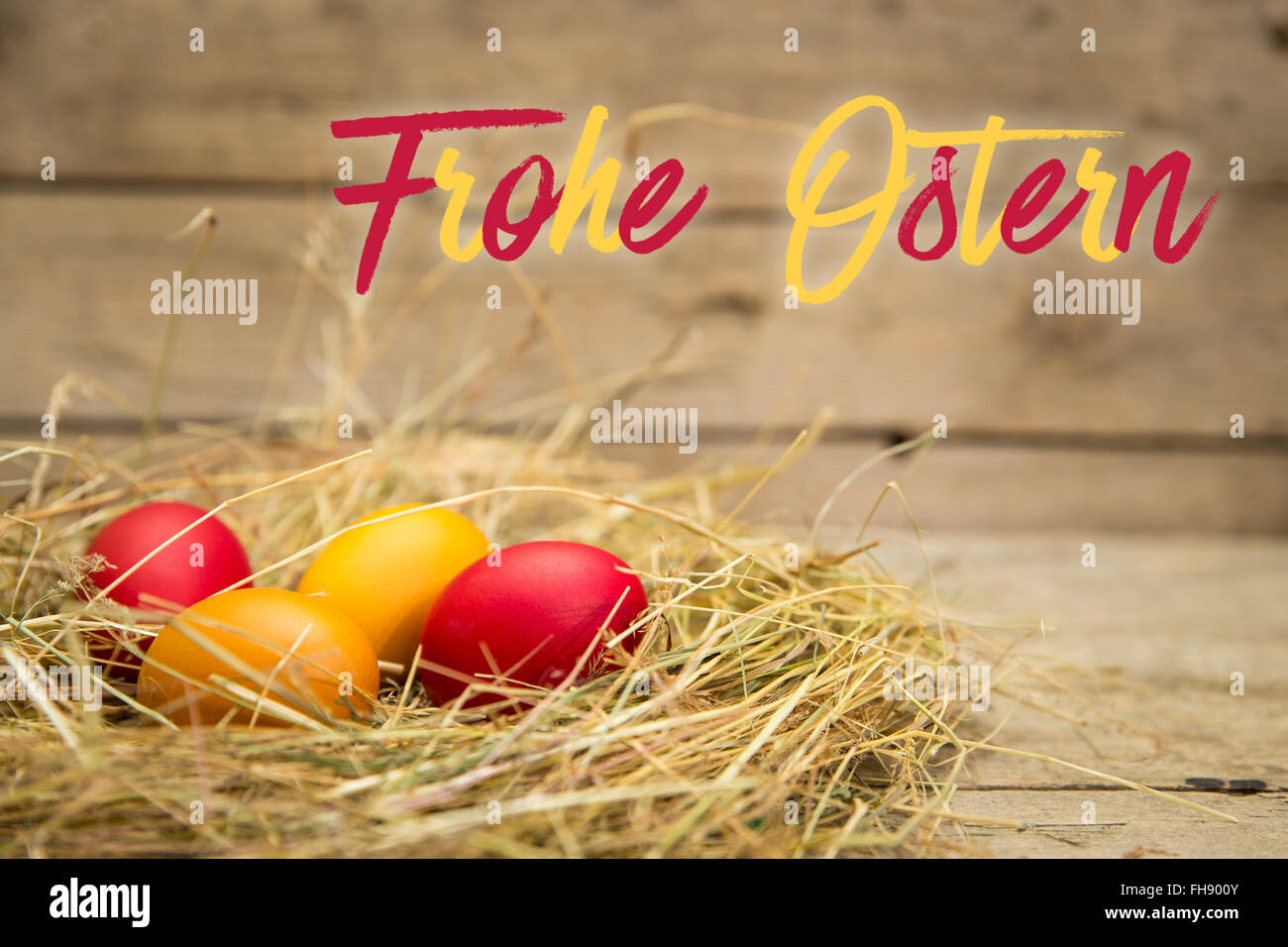 easter nest with german text frohe ostern, which means happy easter. wooden background Stock Photo