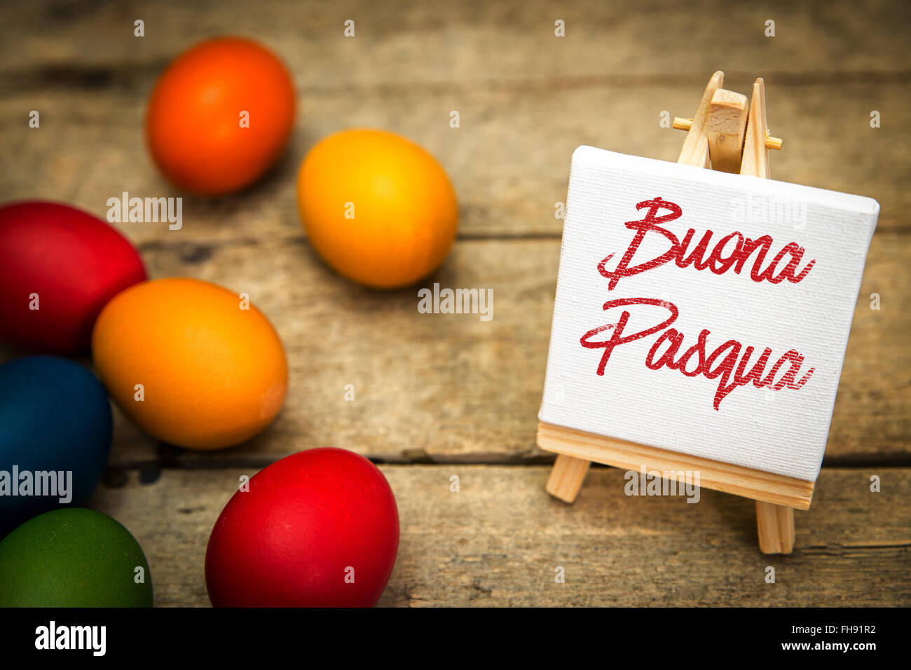 colorful easter eggs with canvas and italian text, buona pasqua, which means happy easter