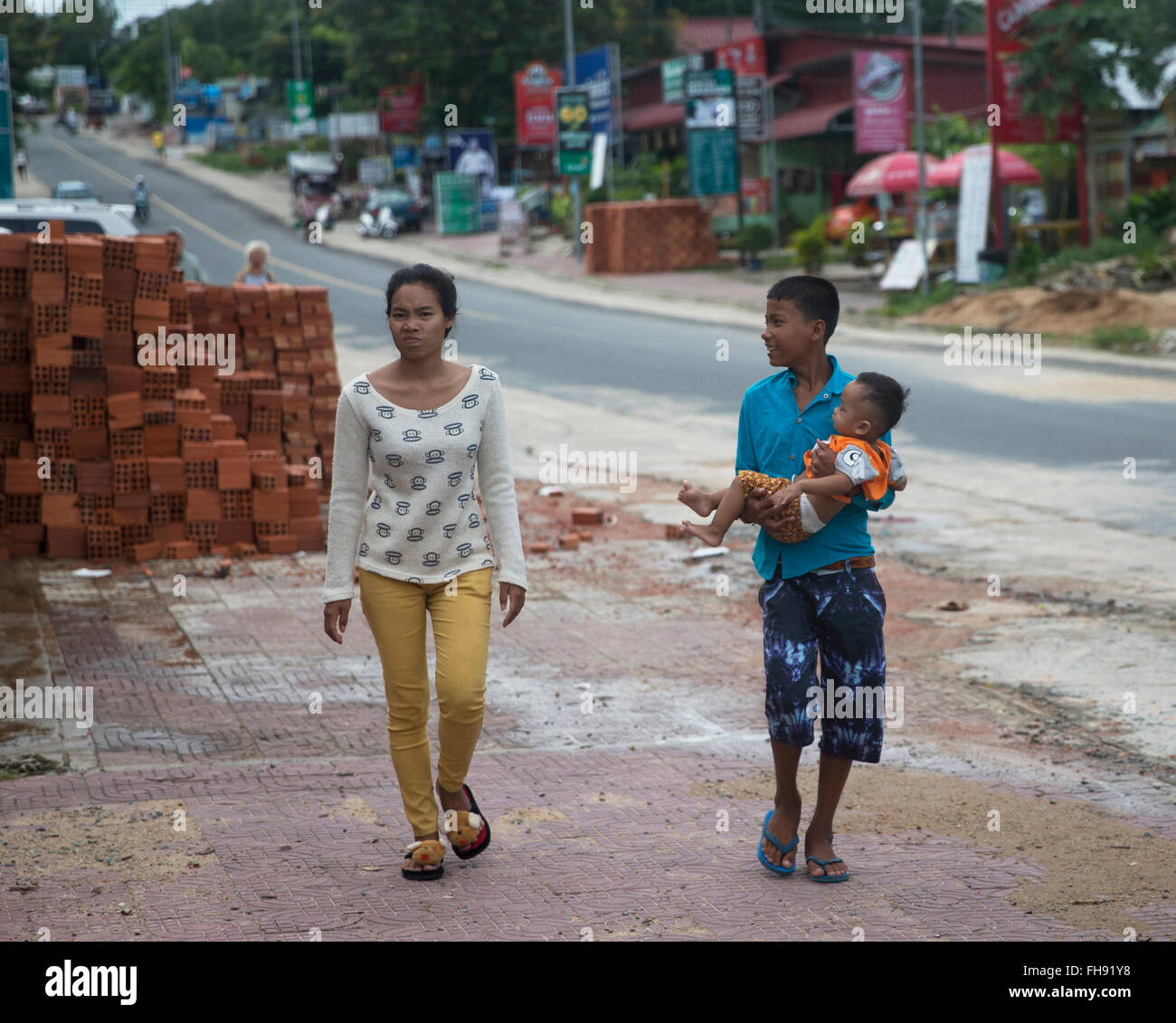 Two women and child in street in Sihanoukville, Cambodia Stock Photo