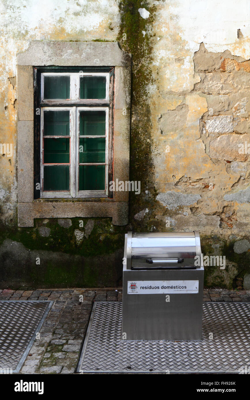 New metal recycling bin for domestic waste outside old stone house, Caminha, northern Portugal Stock Photo