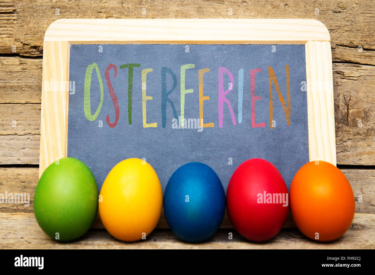 board with colorful eggs and german word osterferien, which means ...