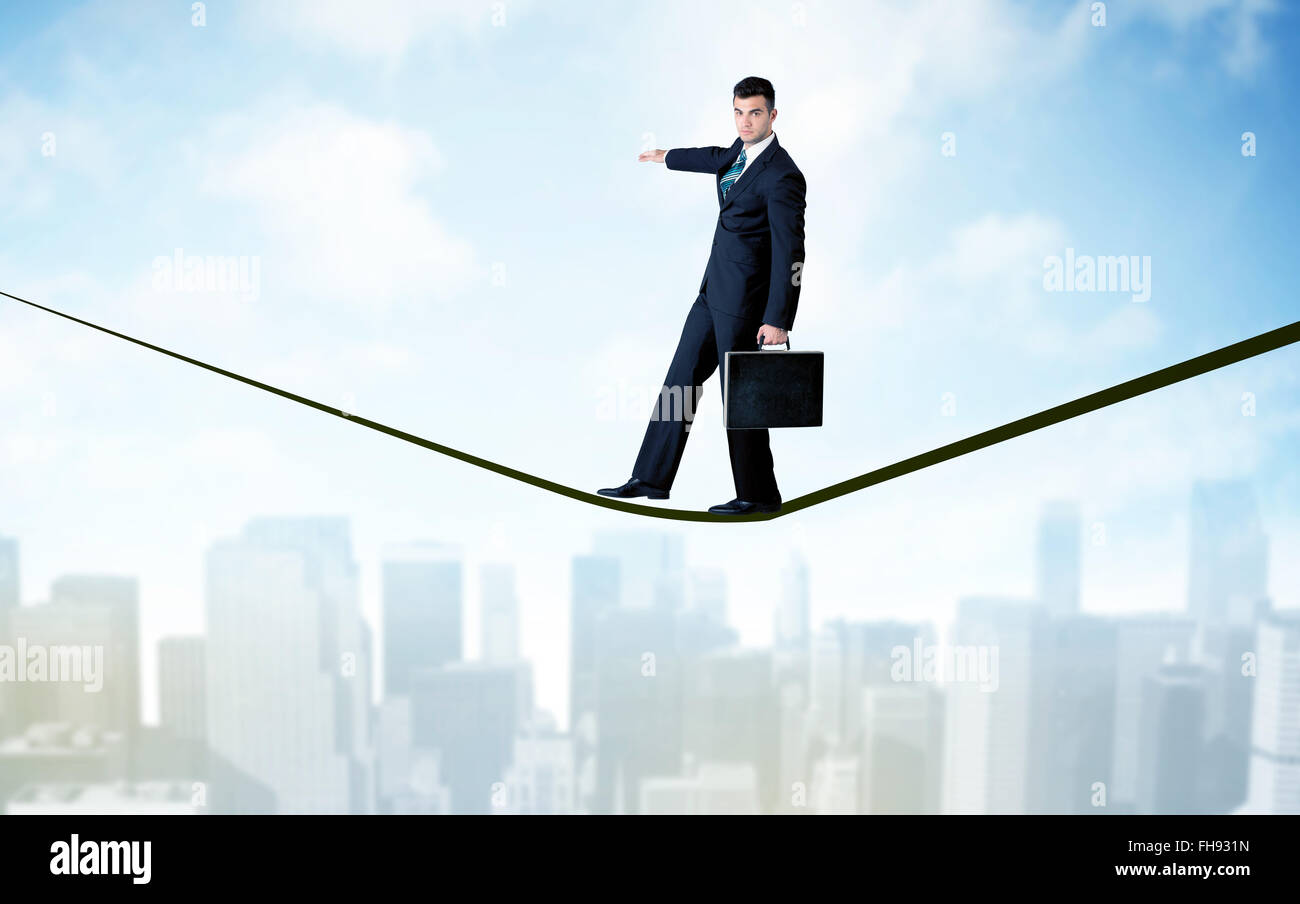 Salesman walking on rope above the city Stock Photo - Alamy