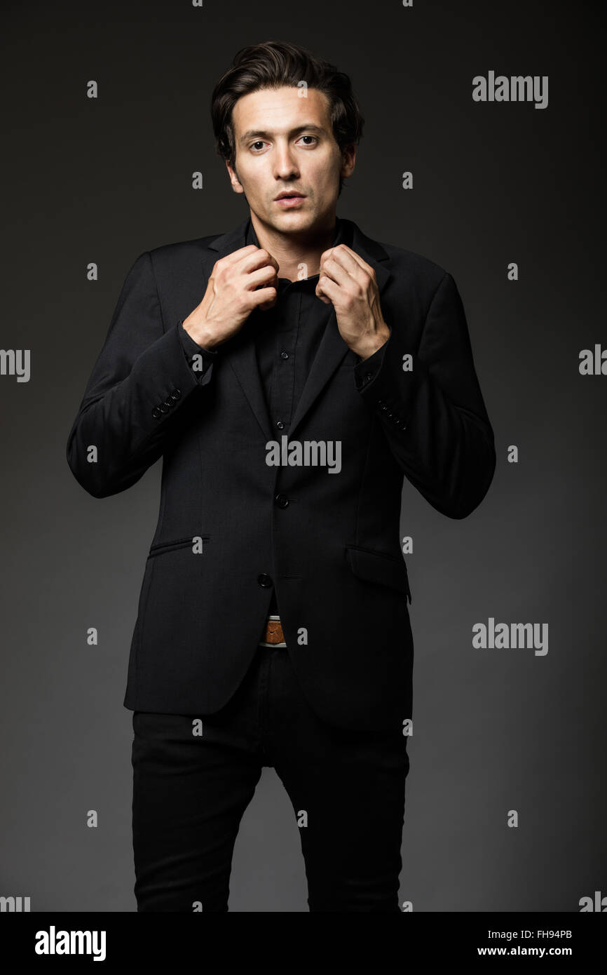 attractive man in black suit on dark background acting Stock Photo