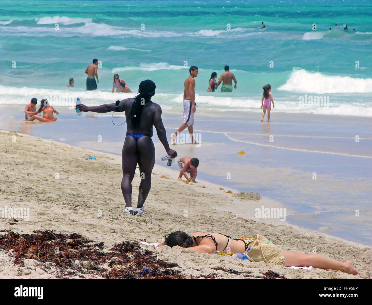 Miami, Florida, USA - May 28, 2007: A man in costume, of African origin, listen to music and do exercises on the beach, while a Stock Photo