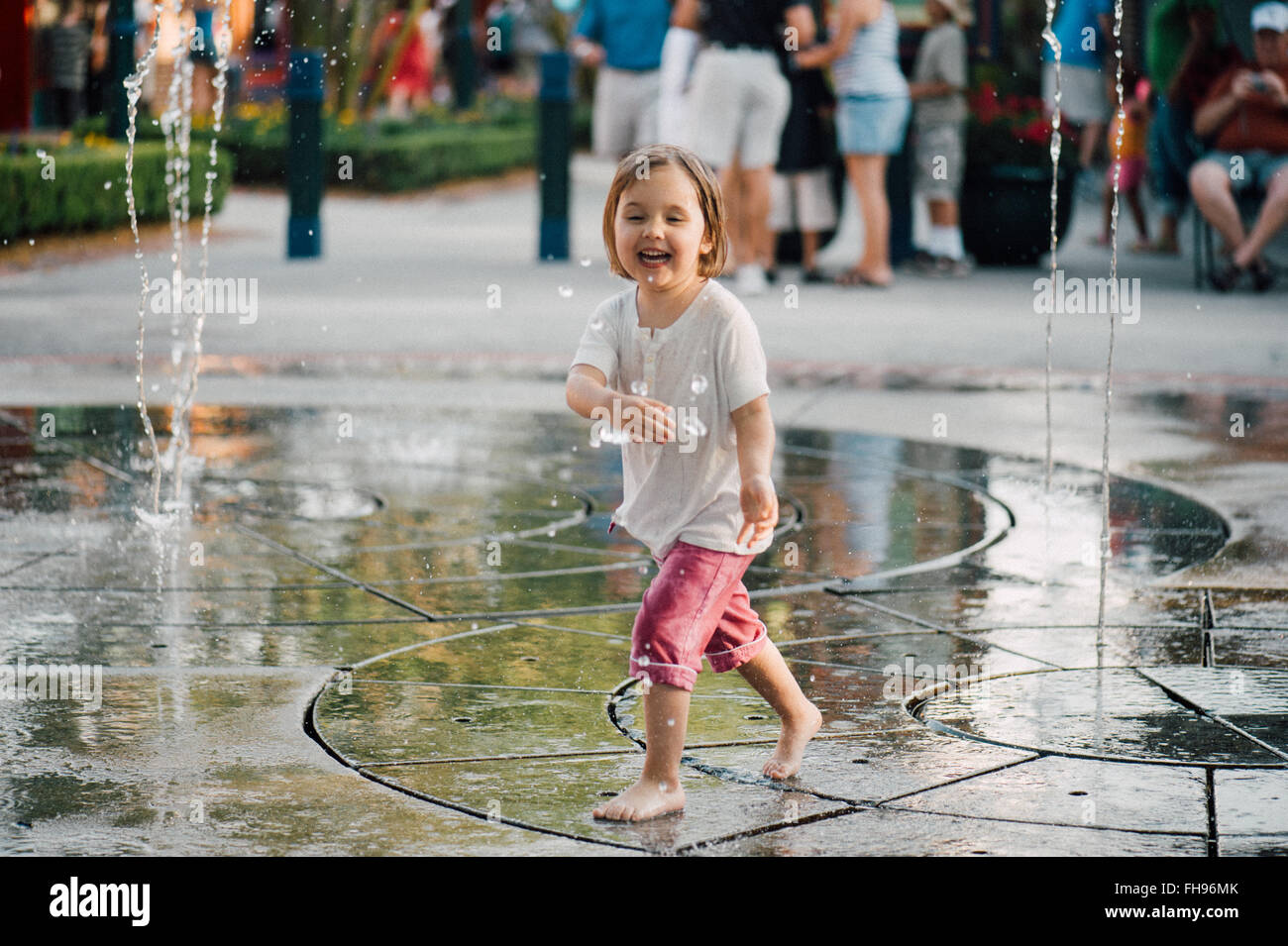 Young kids having fun playing with water fountains at the amusement park of Disney World in Florida US at the beginning of summer. Stock Photo