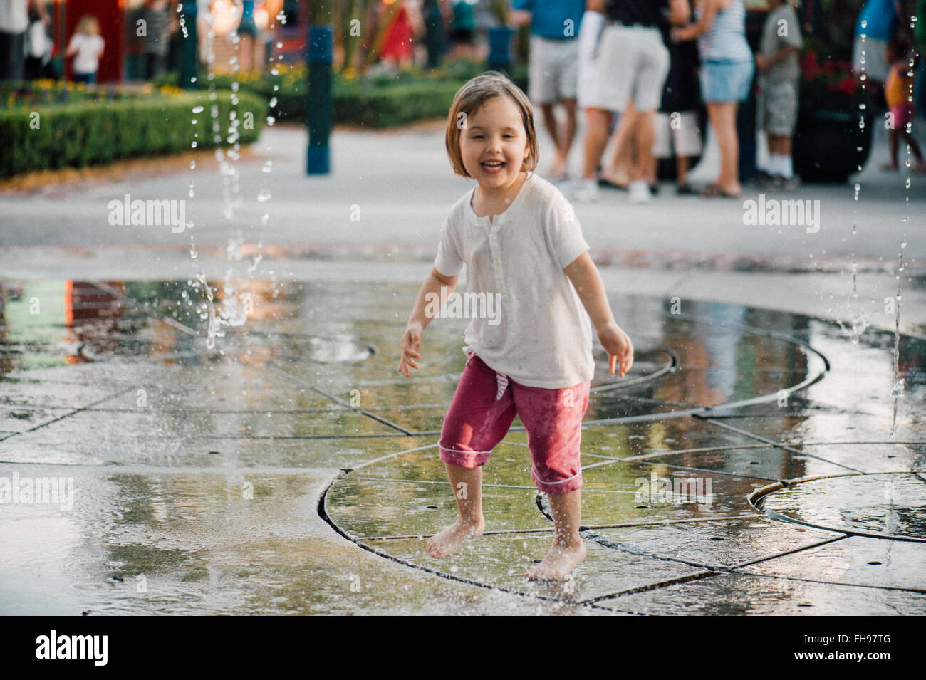 Young kids having fun playing with water fountains at the amusement park of Disney World in Florida US at the beginning of summer. Stock Photo