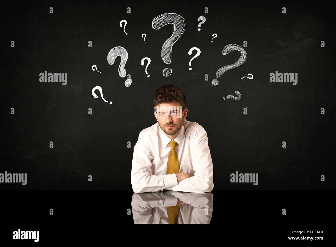 Sitting businessman under question marks Stock Photo - Alamy