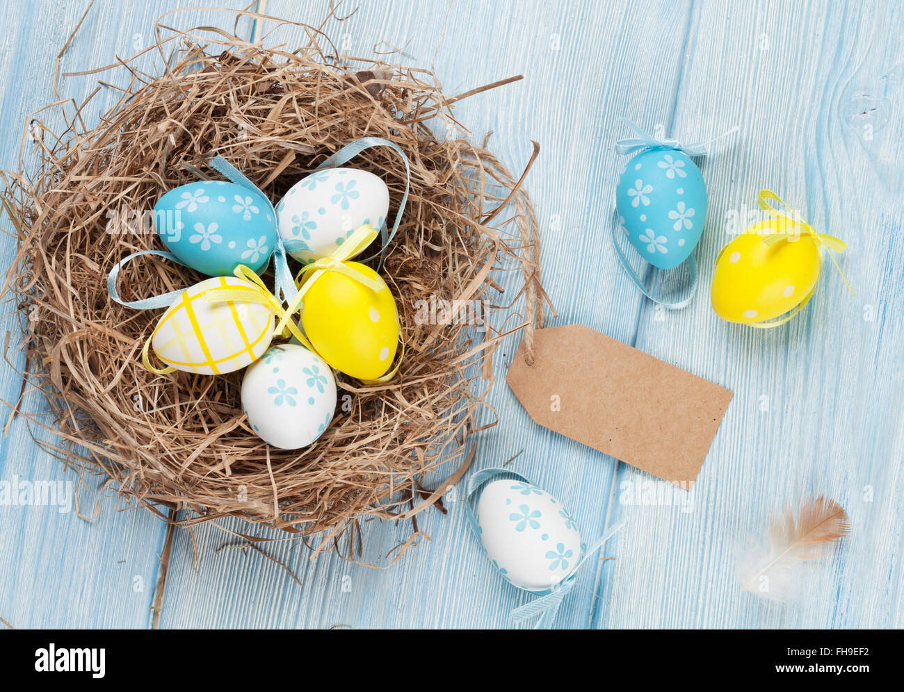 Easter card with eggs in nest over wood. Top view with tag for copy ...