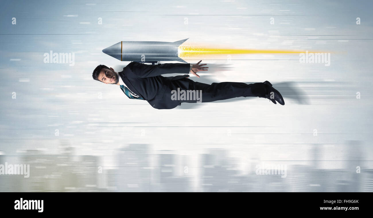 Superhero business man flying with jet pack rocket above the city Stock Photo