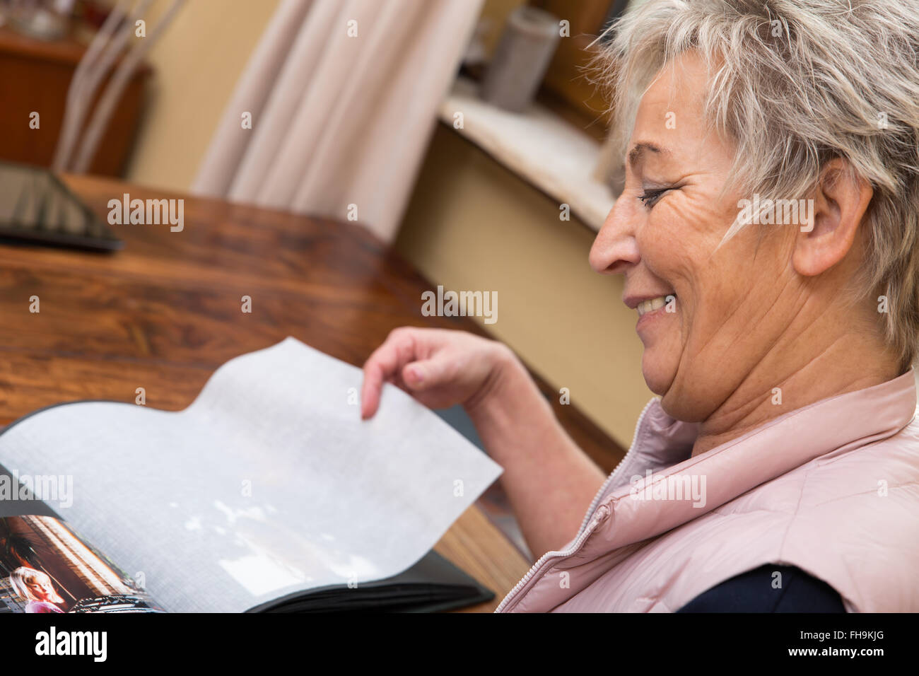senior adult woman is looking into photo album Stock Photo