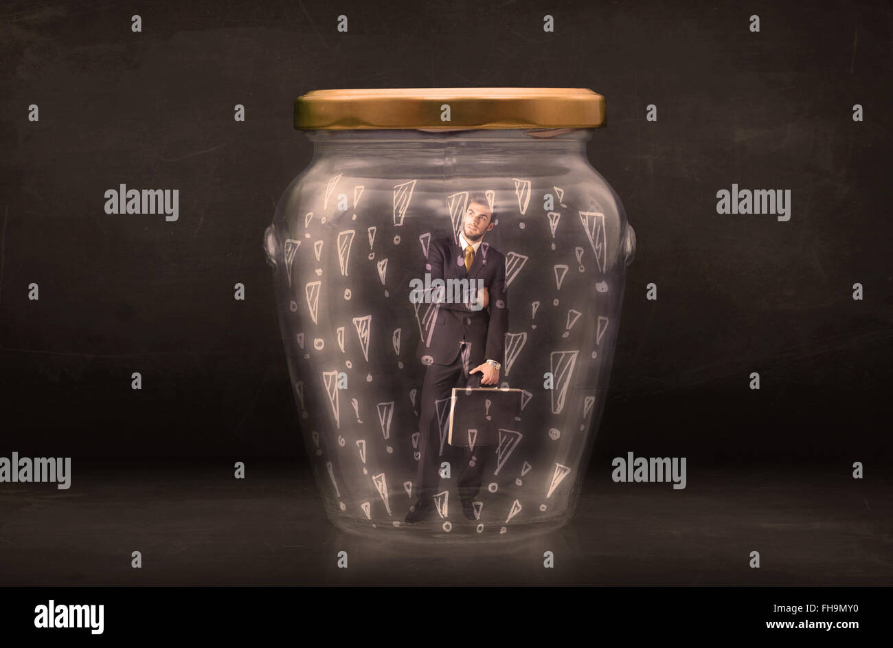Business man trapped in jar with exclamation marks concept Stock Photo