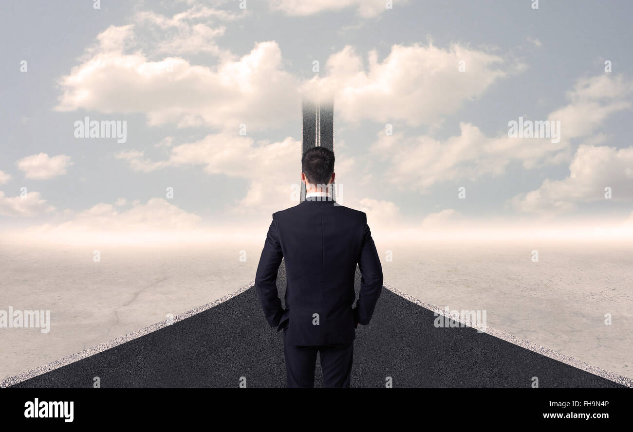 Businessman looking at 3d road that goes up in the sky Stock Photo