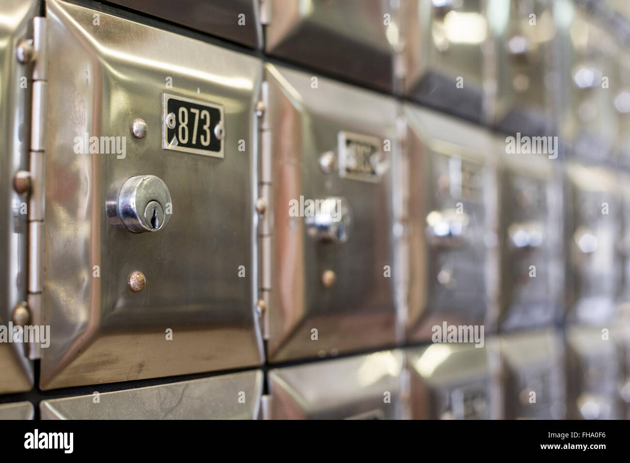 Many po boxes at the post office. The mail boxes are lined up in rows and columns. Selective
