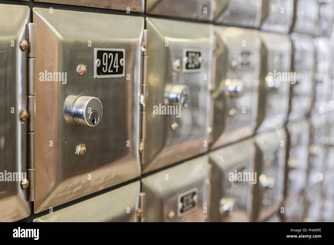 Many po boxes at the post office. The mail boxes are lined up in rows