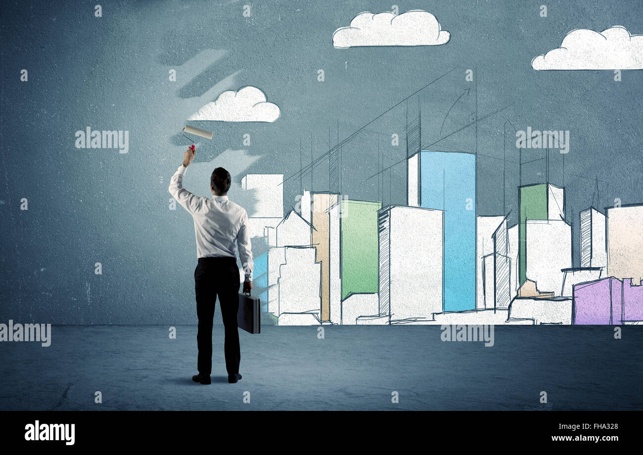 Salesman painting tall buildings on urban wall Stock Photo Alamy