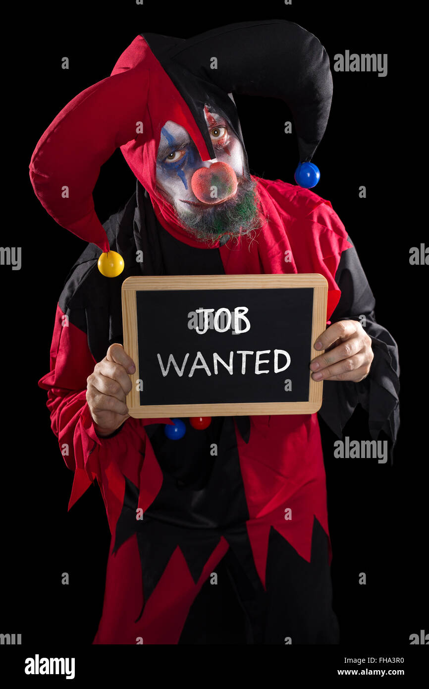 sadly clown holding a slate with text job wanted, concept unemployed and job market, black background Stock Photo