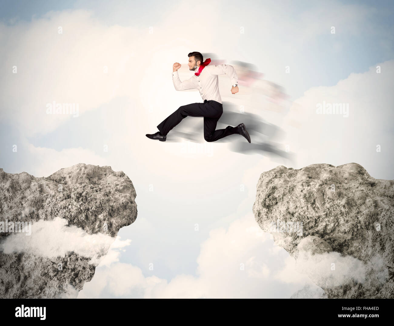 Happy business man jumping over a cliff Stock Photo
