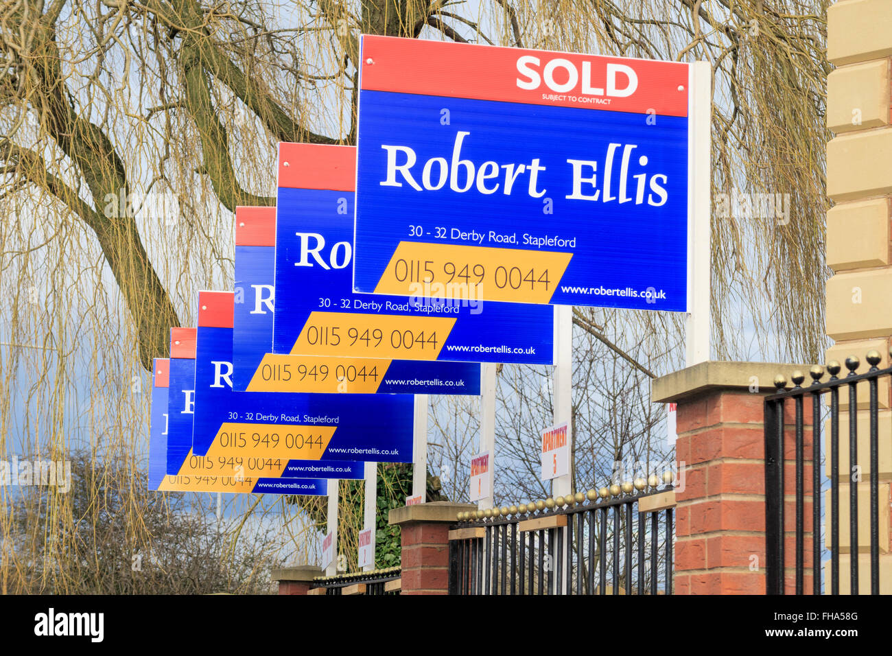 A row of 'Robert Ellis' estate agent house 'sold' signs. In Awsworth