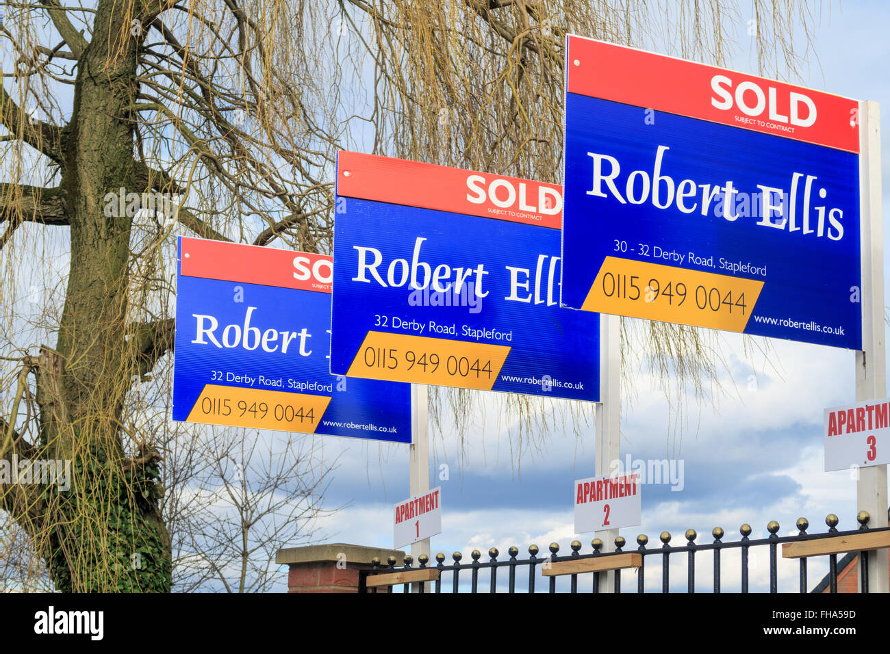 A row of three estate agent house 'sold' signs. In Awsworth