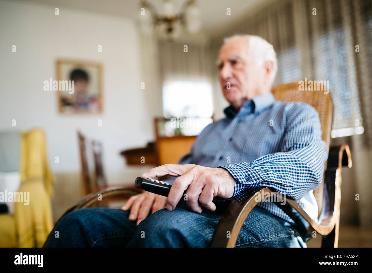 Hand of senior man holding remote control, close-up Stock Photo