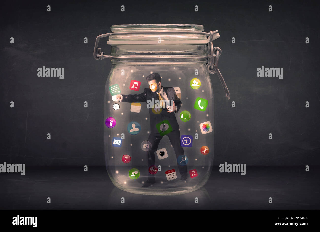 Businessman captured in a glass jar with colourful app icons concept Stock Photo