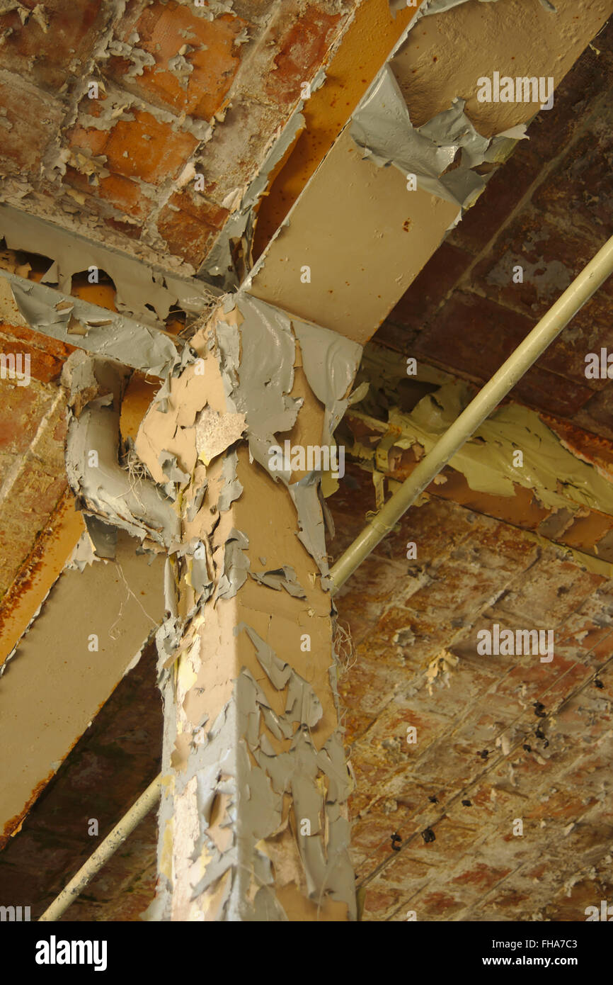 Column And Flaking Paint On The Ceiling Of A Derelict Factory In
