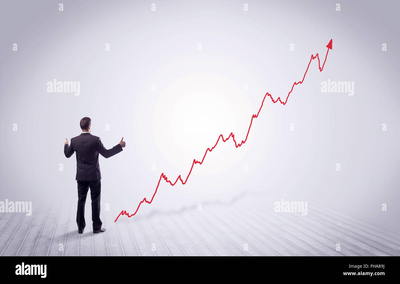 Standing businessman with red graph arrow Stock Photo - Alamy