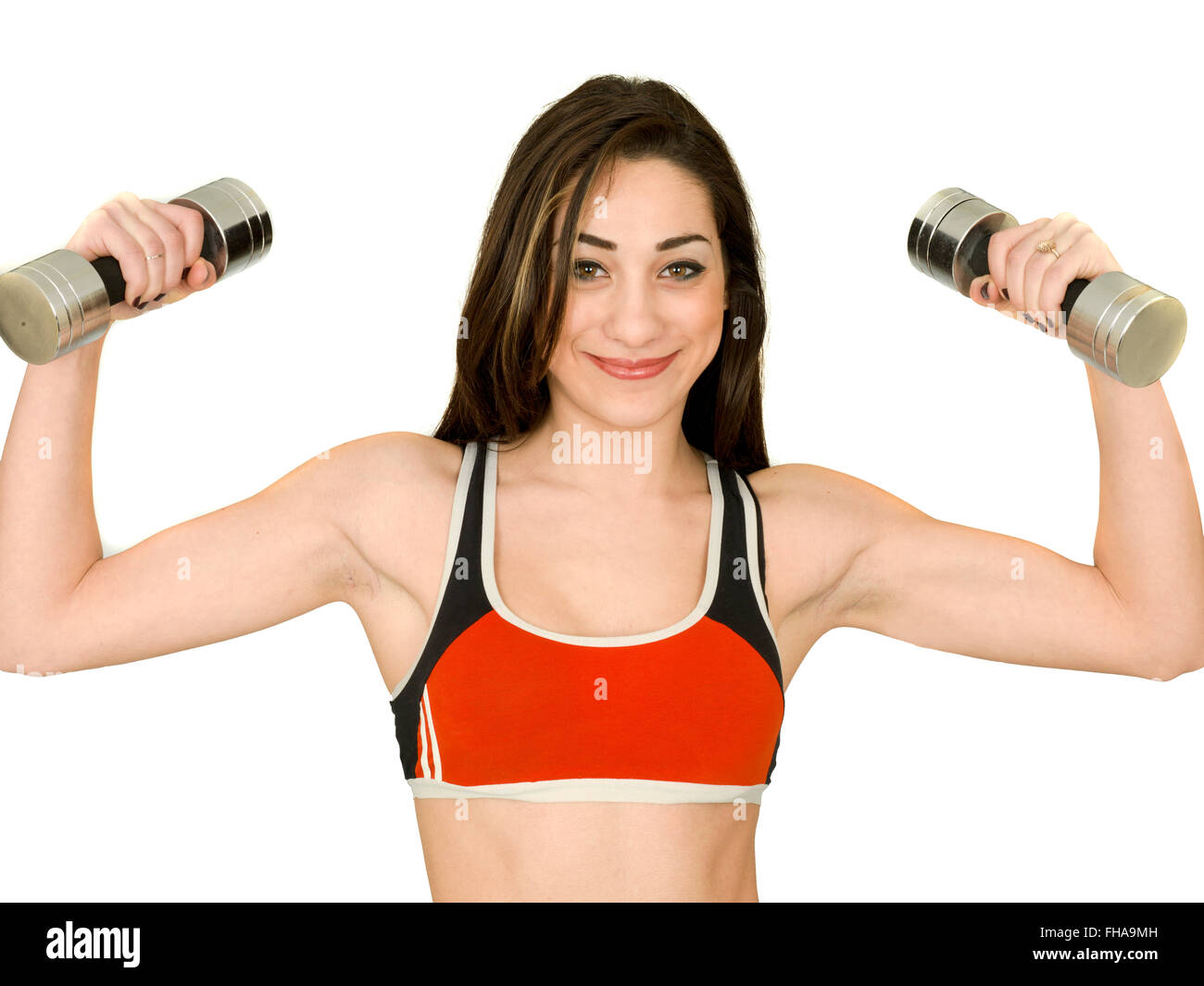 Attractive Fit Healthy Young Woman Exercising Lifting Weights Against A Plain White Background Wearing Sports Clothes Stock Photo